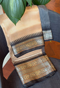 A lovely creamish gold banarasi semi-tissue saree with a gold zari border and black  zari border. The saree also has a black temple woven border. The saree has a gorgeous pallu with rich gold zari detailing.